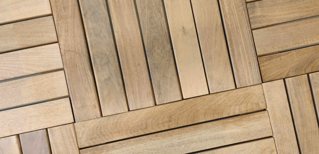 A set of 24x24 deck tiles connected with a quick connector piece from Lumber Plus