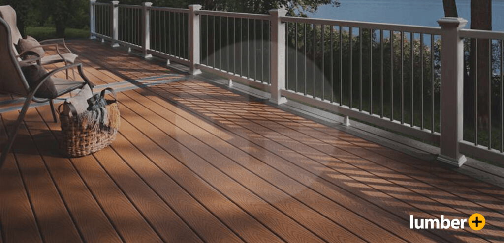 A dark wood deck with a white railing from Lumber Plus.