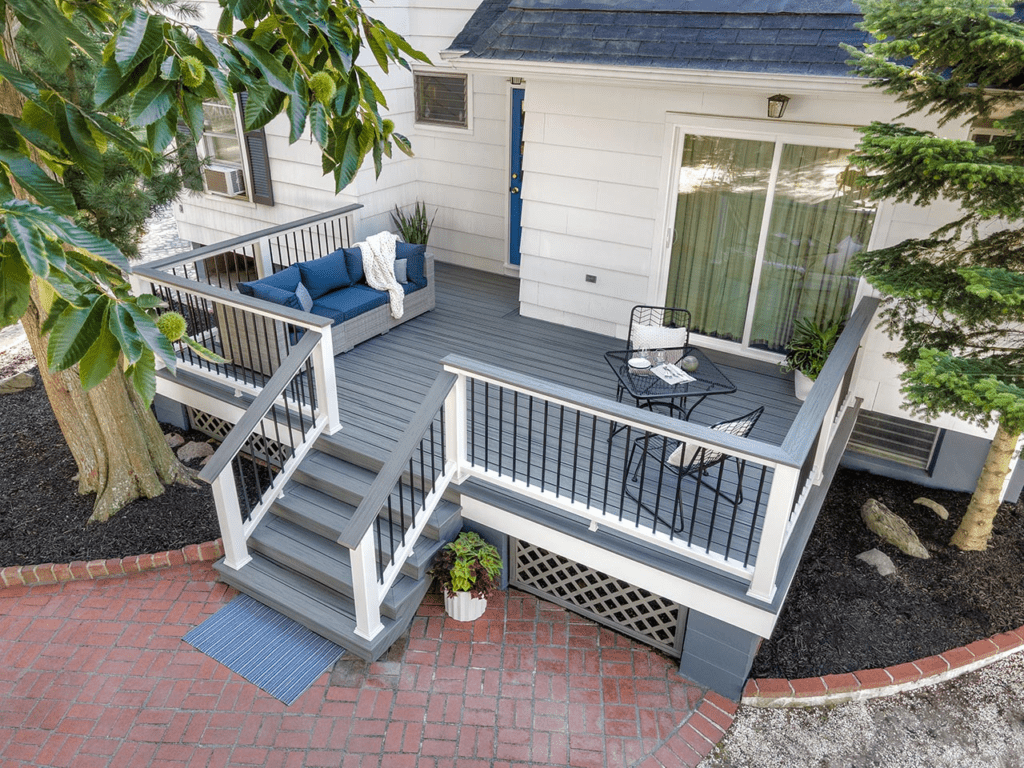 Elevated Trex deck with white railing, gray top rail matching the flooring, and black aluminum infill, creating a sleek, stylish outdoor space.