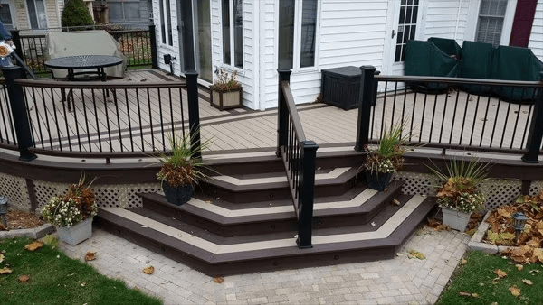 Tan Trex Transcend® deck with dark brown trim, featuring a flared staircase and radius design.