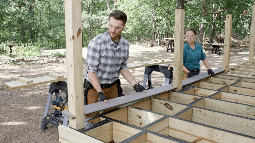 A photo of contractors installing Trex boards on a deck frame.