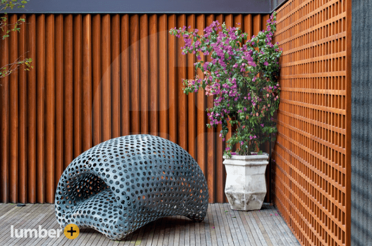 Modern Ipe wood slatted wall with outdoor sculpture.