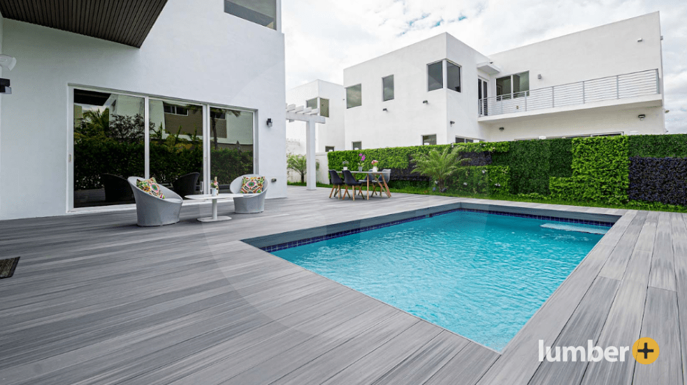Modern composite deck with pool and contemporary outdoor furniture.