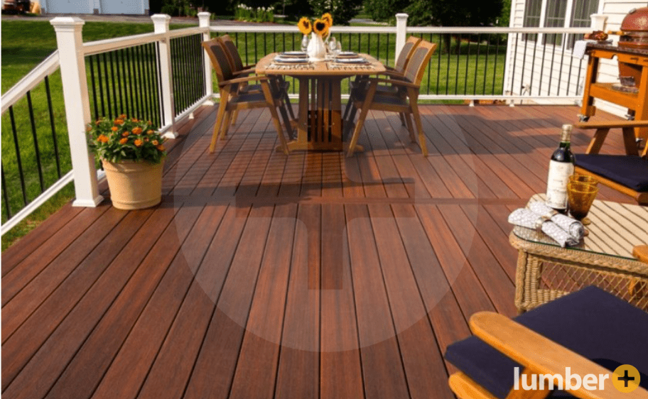 A wooden deck with white railing, set up for summer.