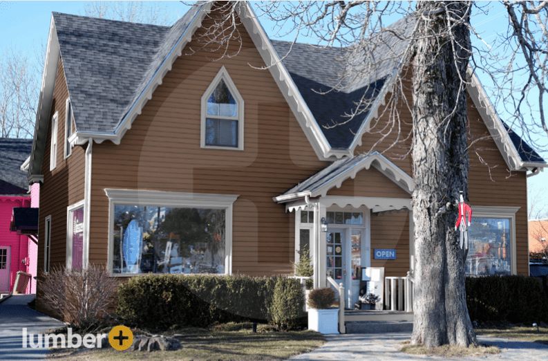 An image of a cottage with light brown vinyl siding.