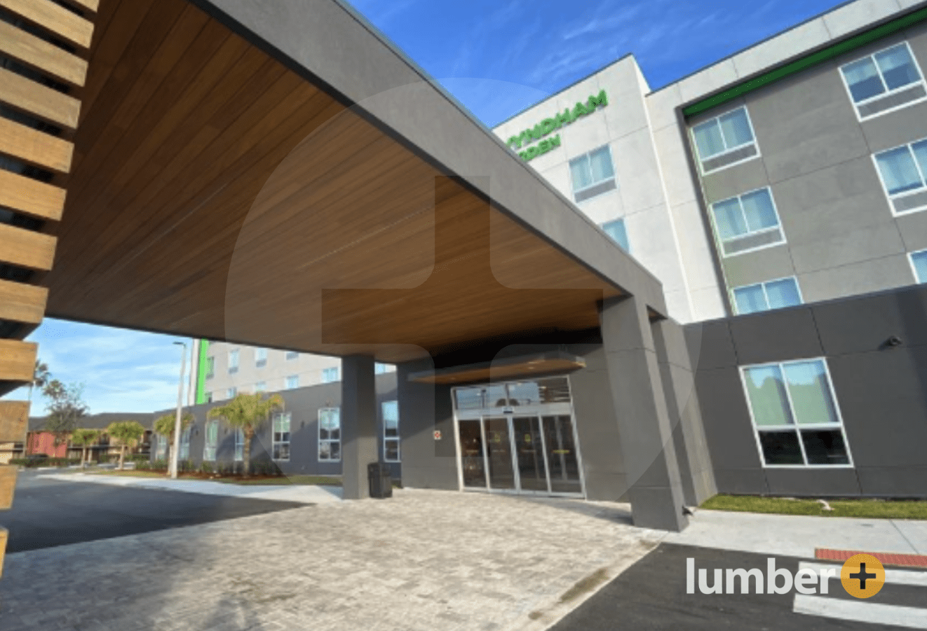 Wood cladding lines the ceiling of a hotel awning. 