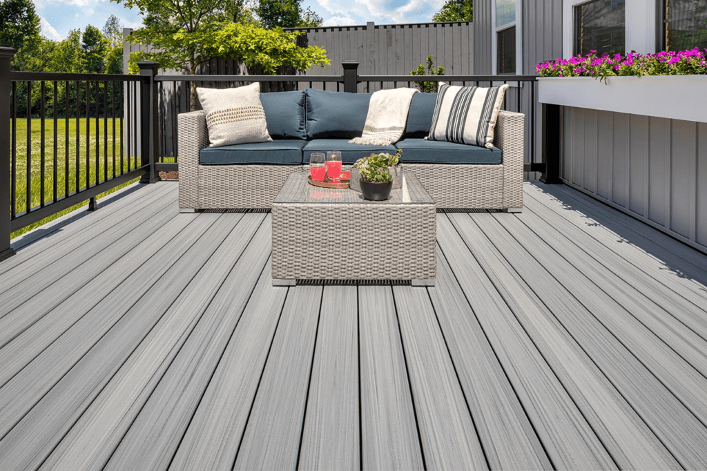 A light gray Trex composite deck with patio furniture and black railing.