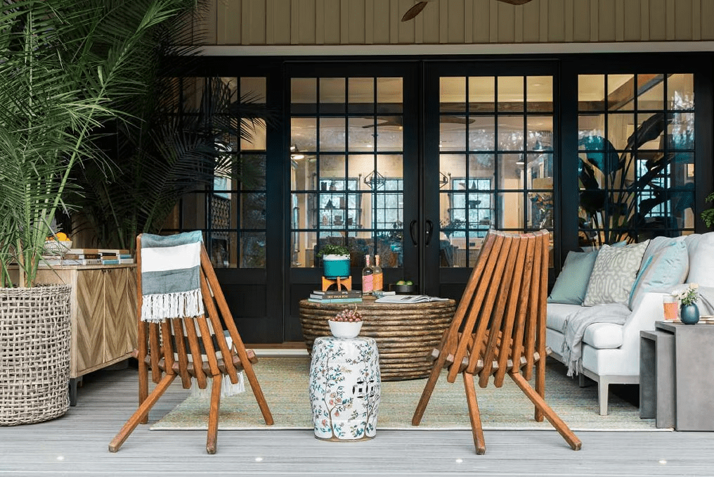 Boho chic patio with Island Mist decking, featuring tropical greenery and a cozy outdoor rug.