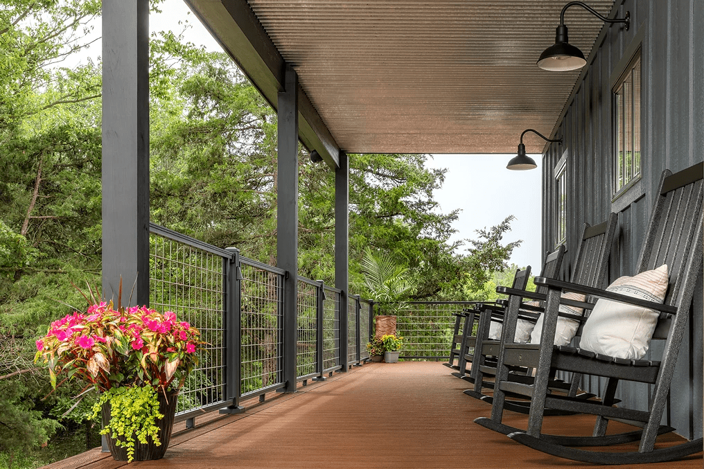 Patio featuring Trex decking in Saddle, mesh railing in Charcoal Black, and rocking chairs for a relaxing outdoor space.