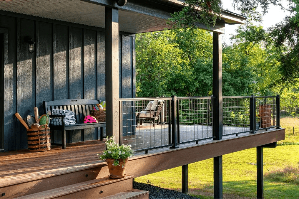 Wrap-around patio featuring Trex decking in Saddle with Charcoal Black mesh railing and a matching bench for a stylish outdoor retreat.