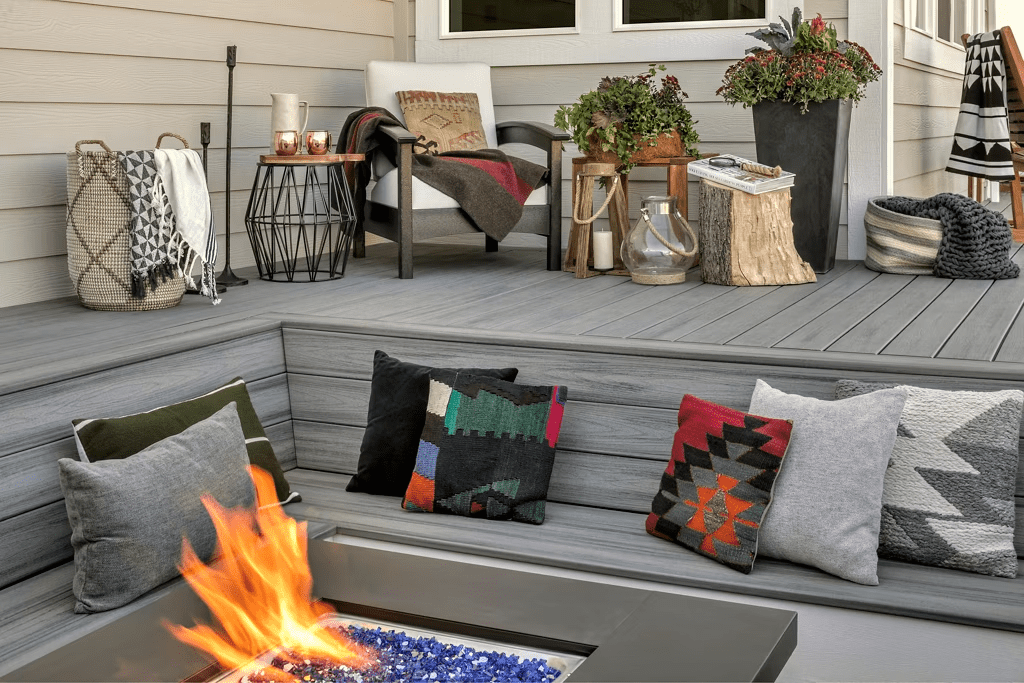 Trex Transcend® Island Mist decking with built-in step-down benches surrounding a fire pit, showcasing Trex deck bench ideas for a cozy outdoor retreat.