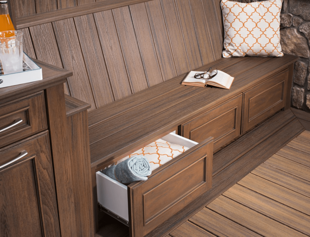 Dark brown bench with storage compartments and a matching table, showcasing Trex deck bench ideas that combine functionality and elegance in an outdoor space.