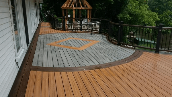 Brown and gray Trex deck with custom dark brown curves and a triangular inlay, highlighting Trex color combinations.