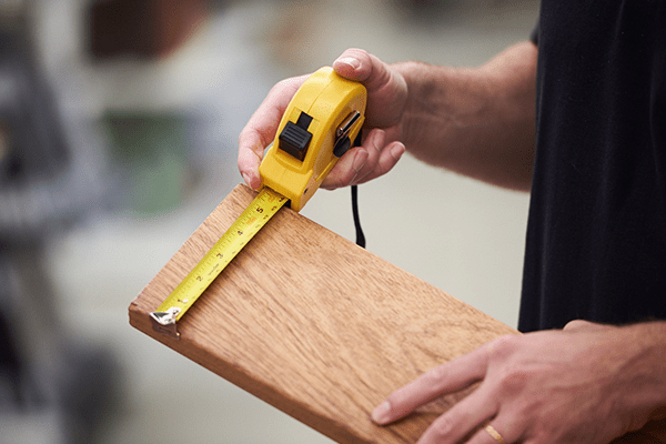 a man holding and measuring wood to start building a deck in Florida