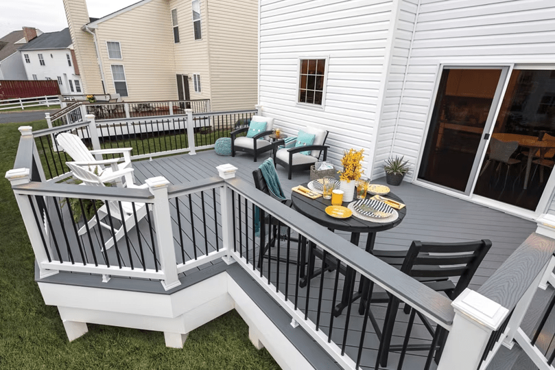 Unique-shaped Trex deck with gray rails, white balusters, and aluminum infill for a striking contrast.