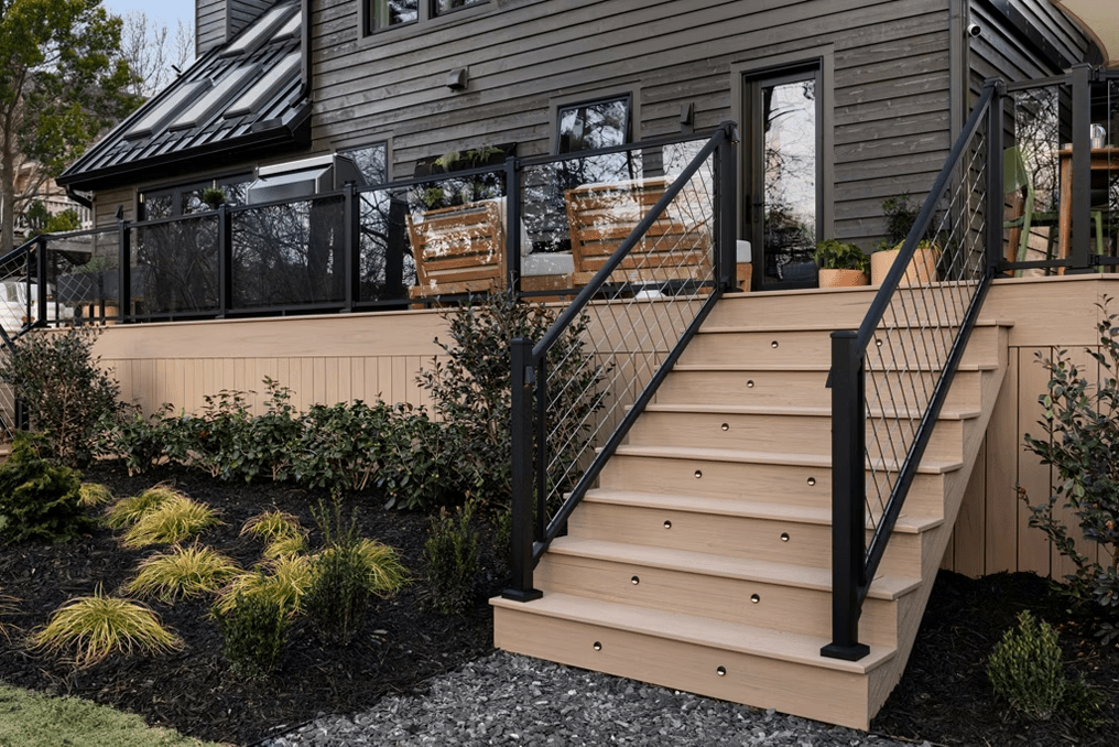 Trex deck with black railing featuring glass infill on the deck and mesh infill on the staircase, combining sleek visibility with modern texture.