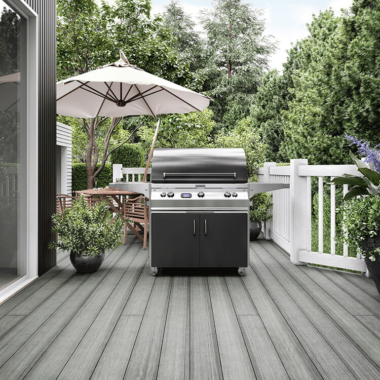 A beach gray composite deck with a grill and outdoor dining table
