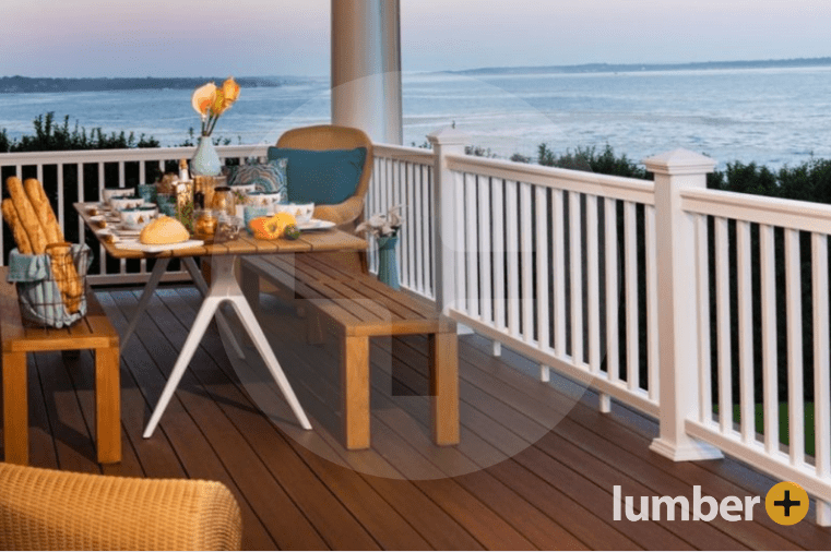 Dark brown composite Fiberon® deck with an outdoor table and white railings.