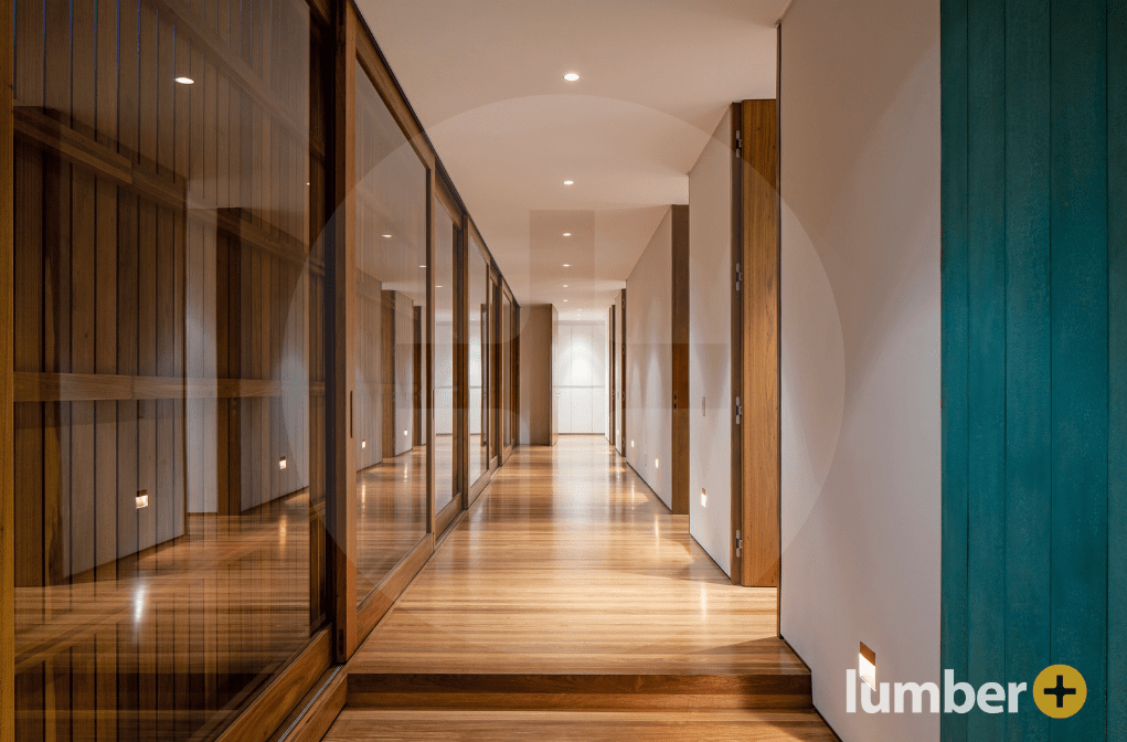 Modern hallway with glass walls and wooden flooring.