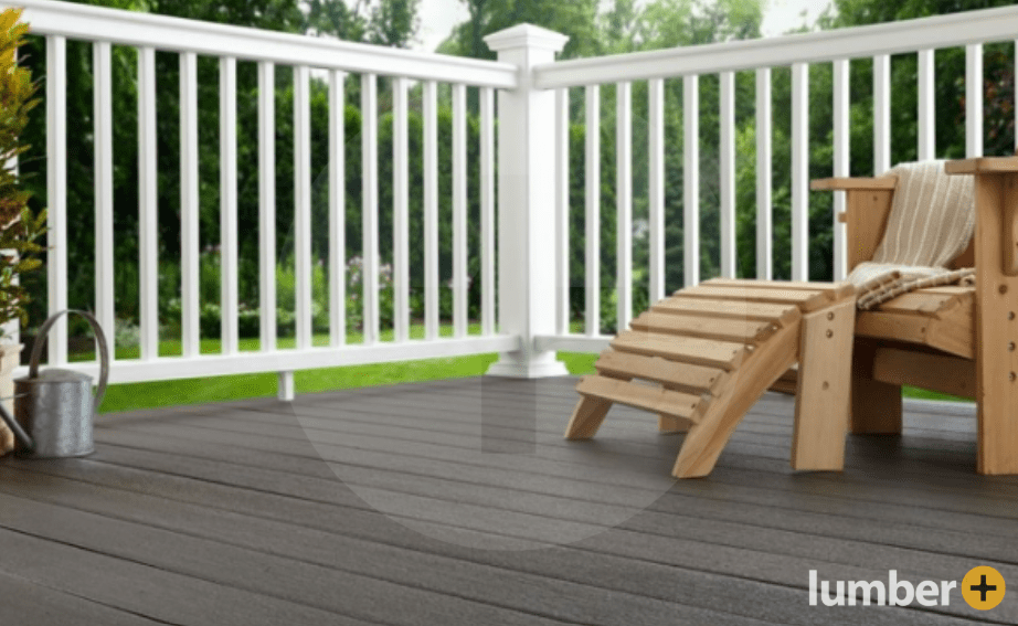 A deck with a wooden Adirondack chair and white railing.