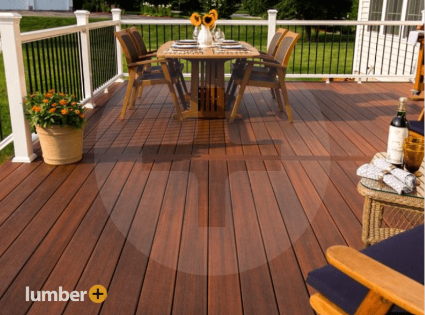 Warm red wood decking on a back patio with white open fence railing and outdoor dining area.