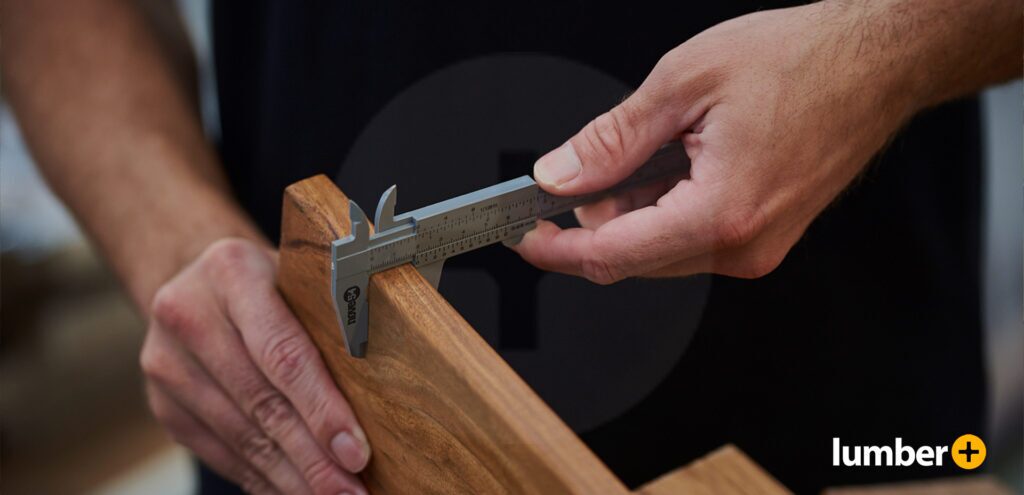 Picture of a man using a measuring tool, an essential resource for a deck project.