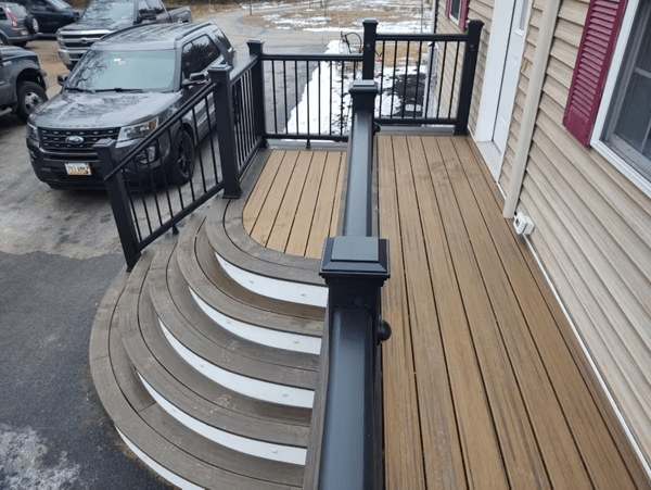 Steps with curved Trex decking lead to the front door of a house.